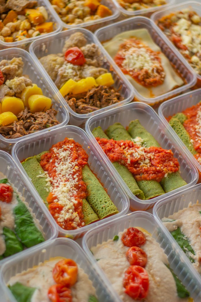 An assortment of healthy, colorful meal prep boxes featuring vegetables, grains, and proteins.